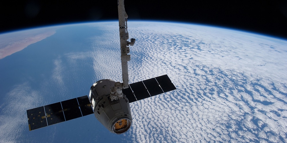 Het Dragon bevoorradingstuig wordt 'vastgegrepen' met de Canadarm2 robotarm van het ISS